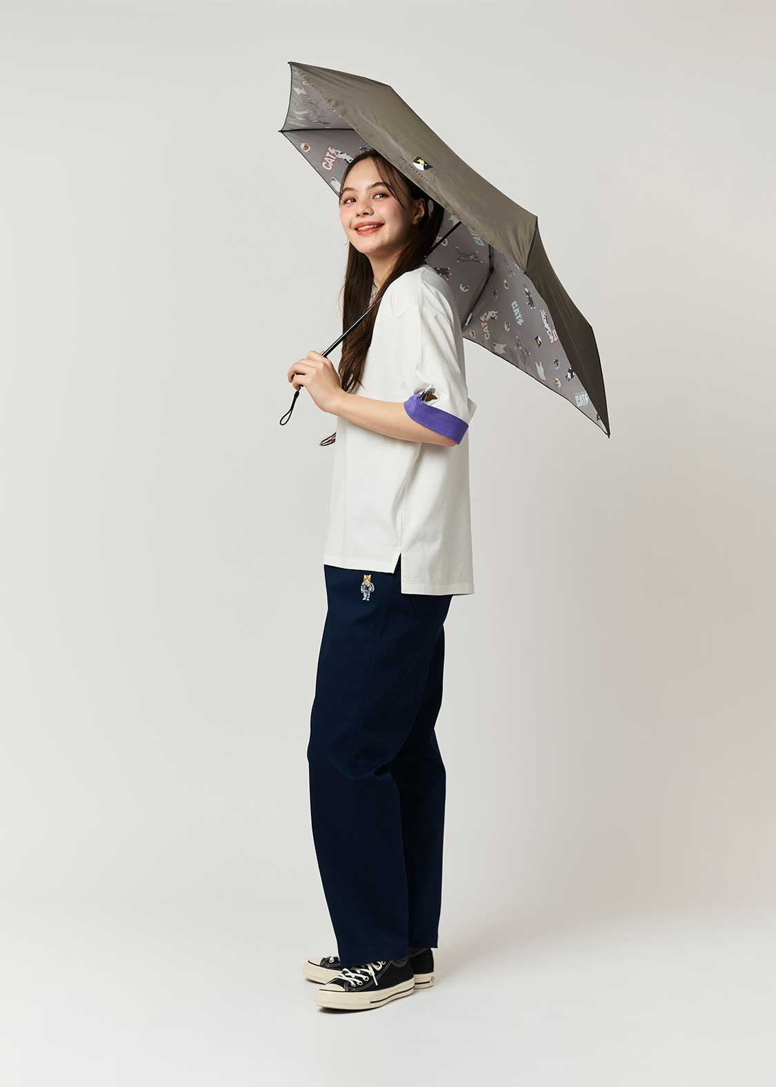 Person holding a large umbrella against a plain background