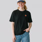 Via Artists oversized black cotton t-shirt with small apple embroidery worn by a model in jeans and a baseball cap
