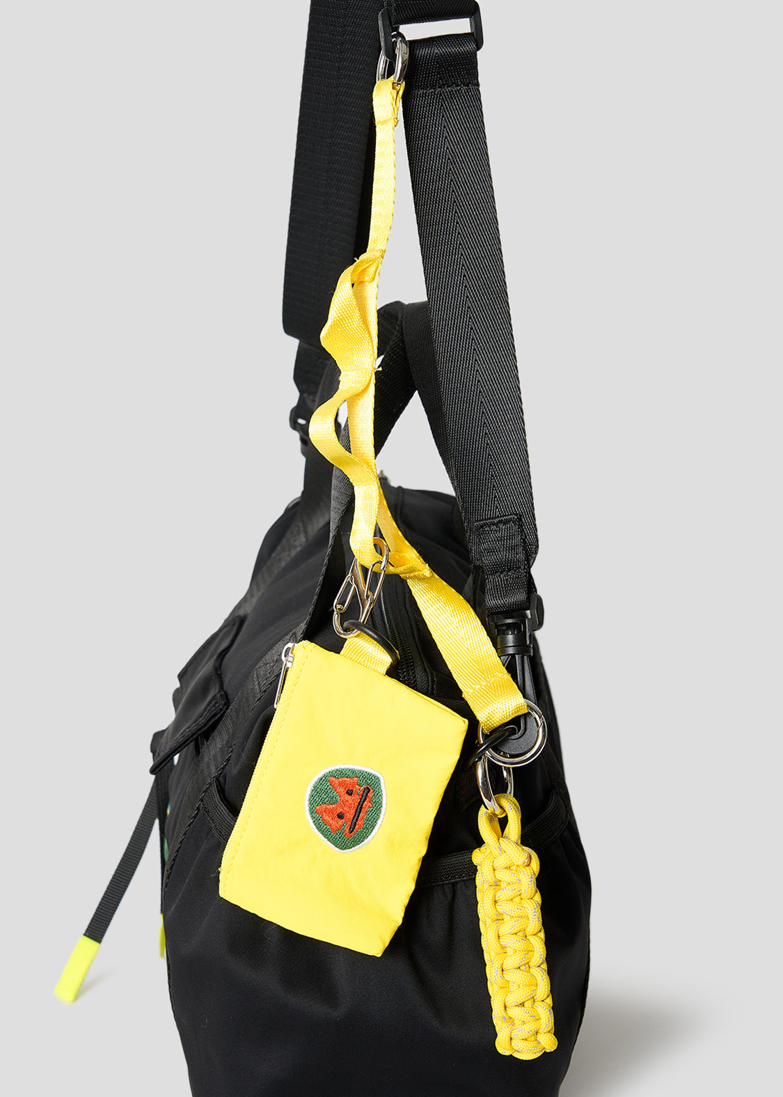 Via Artists black nylon Boston shoulder bag featuring a yellow detachable mini pouch and wrestling mask embroidery