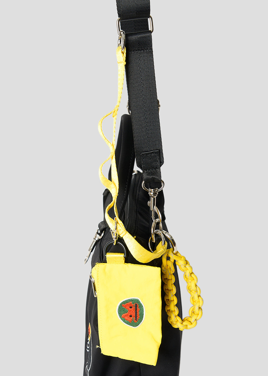 Via Artists black nylon shoulder bag with a yellow mini pouch and wrestling mask embroidery detail