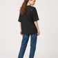 Via Artists black peach-brushed cotton unisex t-shirt with 5/8 sleeves, worn by a woman with blue jeans, back view.