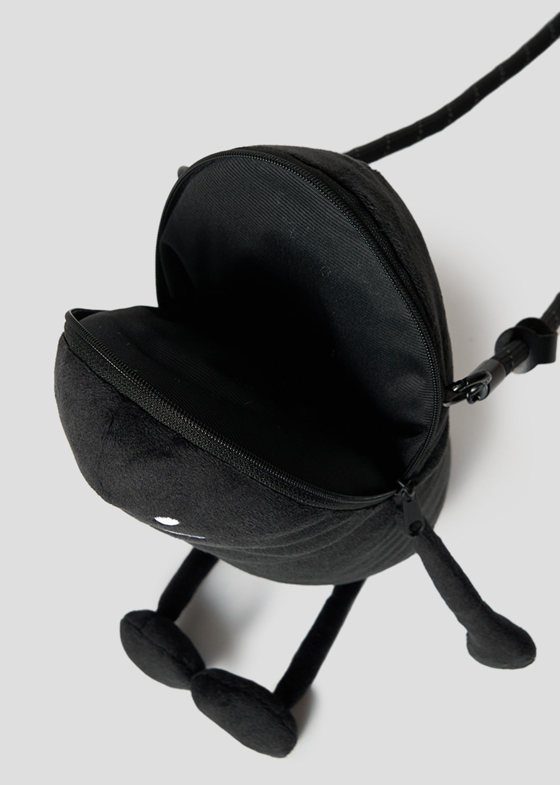 Via Artists Beautiful Shadow plush pouch in black with a zippered opening, long limbs, and a crossbody strap.