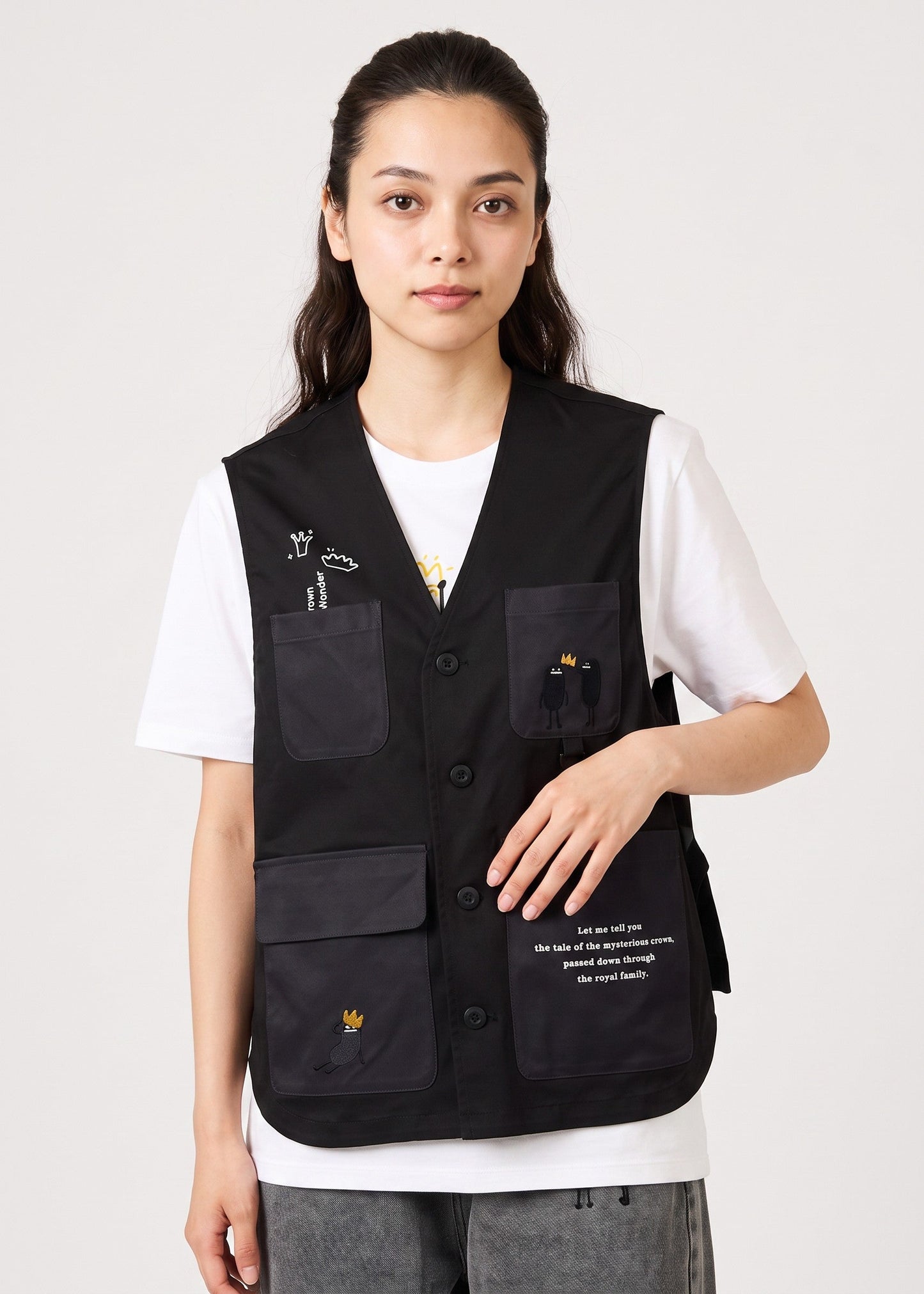 Via Artists black polyester vest with embroidered crown characters and front pockets worn by a female model
