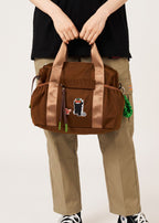 Via Artists Ikaku Lucha Boston shoulder bag in brown nylon with an embroidered red panda wrestler design