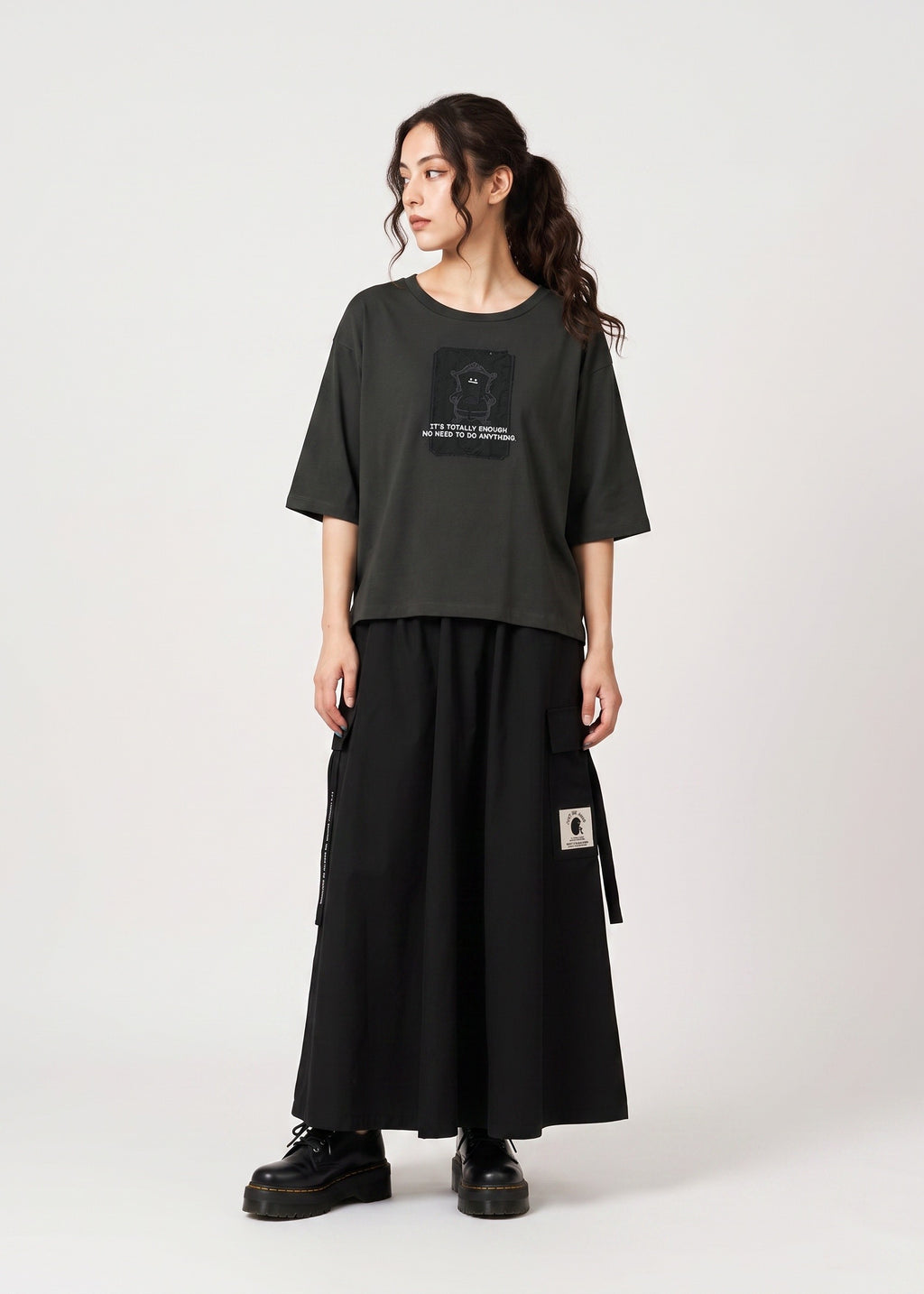 Via Artists cropped dark grey jersey T-shirt with Beautiful Shadow graphic, worn by a model with a black maxi skirt.
