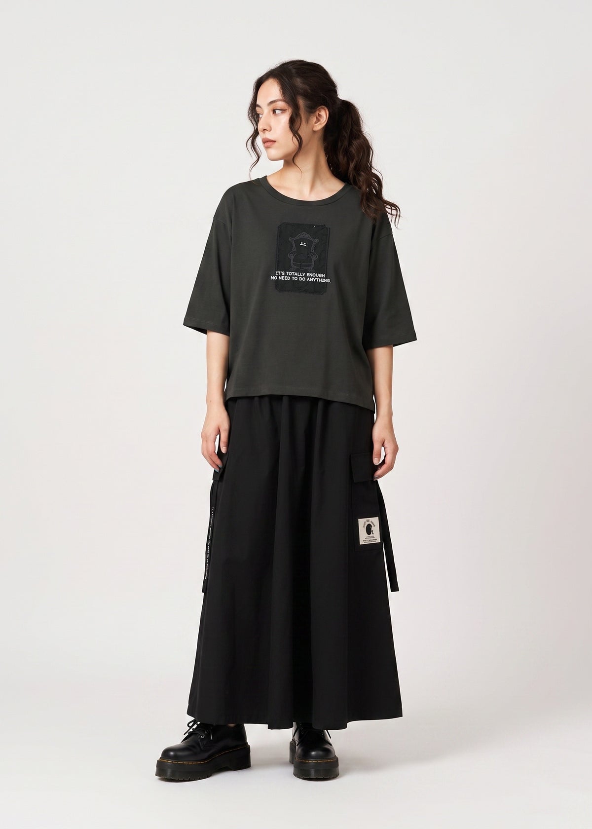 Via Artists cropped dark grey jersey T-shirt with Beautiful Shadow graphic, worn by a model with a black maxi skirt.