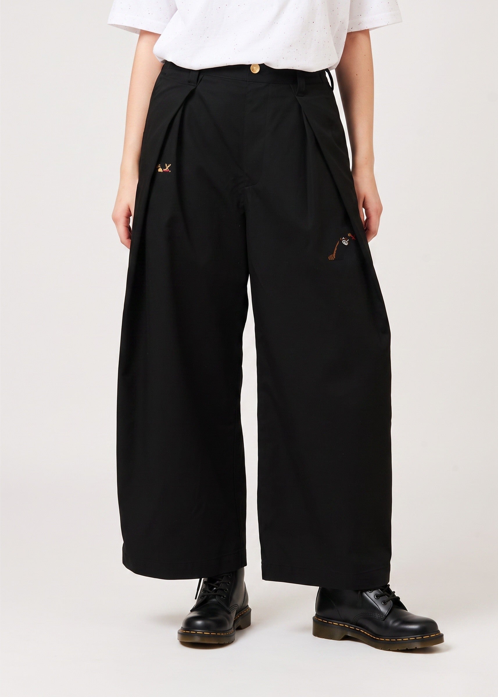 Via Artists Ikaku Royal DRK wide-leg pleated black pants with red panda embroidery, worn with a white top.