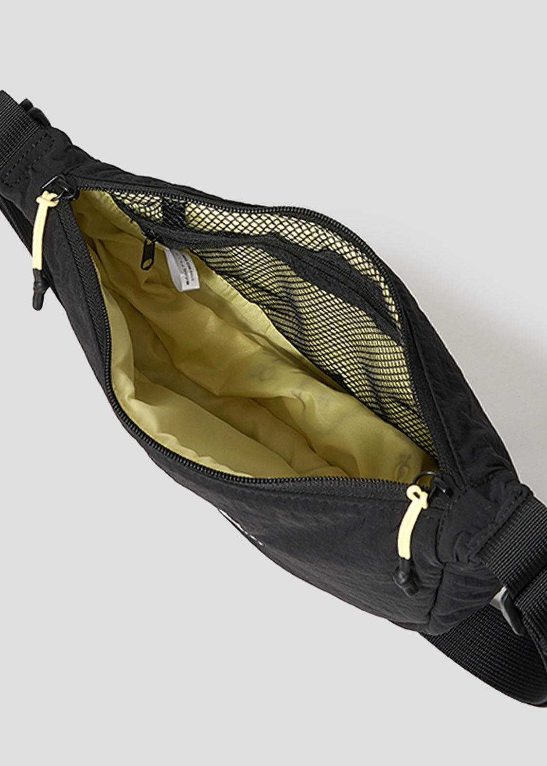 Via Artists Nemuran mini shoulder bag in black nylon with an open zipper showing a yellow interior and mesh pocket