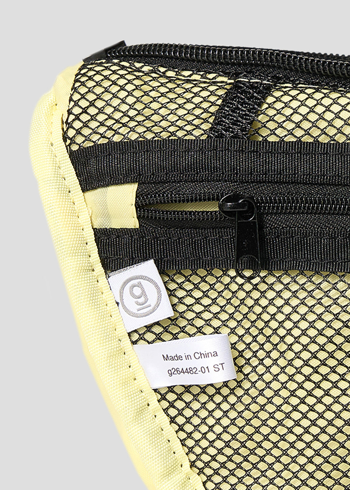 Via Artists Nemuran mini shoulder bag interior featuring a black mesh pocket, zipper, and key loop on yellow nylon