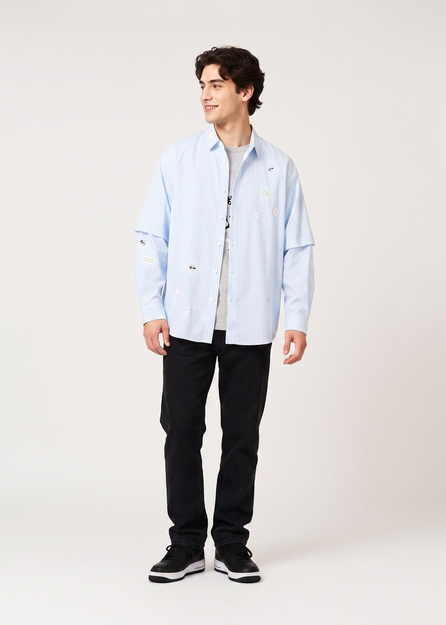 Via Artists Rolling Pandas detachable sleeve shirt in light blue stripe with panda embroidery on a male model.