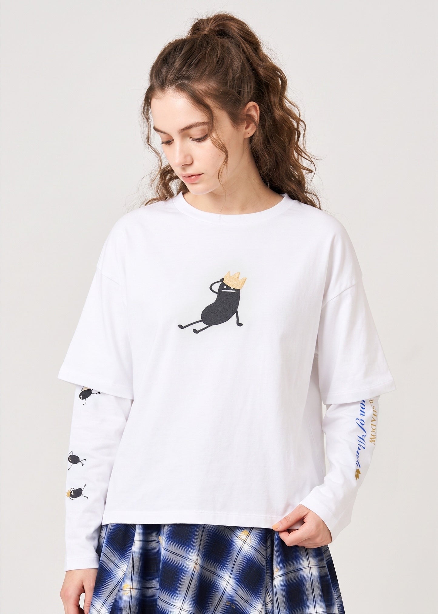 Via Artists white layered long-sleeve cotton t-shirt featuring a black character embroidery with a gold crown